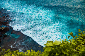 A beautiful ocean in Bali. The Pacific Ocean with large waves and tides that break on the rocks. The Indian Ocean is blue. Aqua Mente and Phantom Blue. Golden sunset on the ocean on the island of Bali