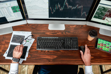 Get success. Top view of businessman, trader working, sitting by desk in front of multiple computer...