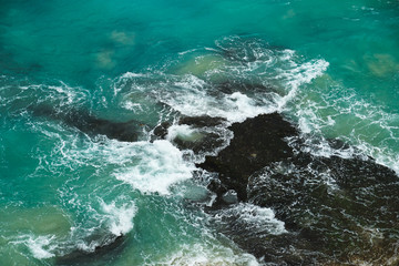 A beautiful ocean in Bali. The Pacific Ocean with large waves and tides that break on the rocks. The Indian Ocean is blue. Aqua Mente and Phantom Blue. Golden sunset on the ocean on the island of Bali