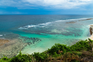 A beautiful ocean in Bali. The Pacific Ocean with large waves and tides that break on the rocks. The Indian Ocean is blue. Aqua Mente and Phantom Blue. Golden sunset on the ocean on the island of Bali