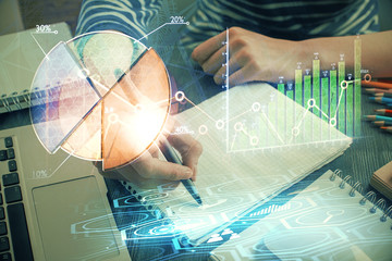 Financial chart drawn over hands taking notes background. Concept of research. Double exposure