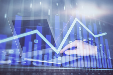 Double exposure of stock market graph with man working on laptop on background. Concept of financial analysis.