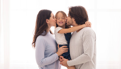 Loving Parents Kissing Their Cute Little Daughter From Both Sides