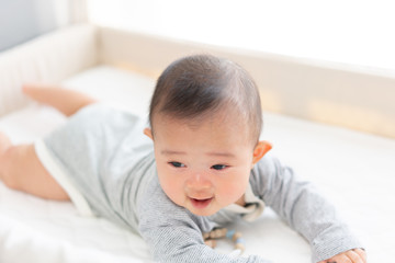 ベビーベッドで遊ぶ赤ちゃん