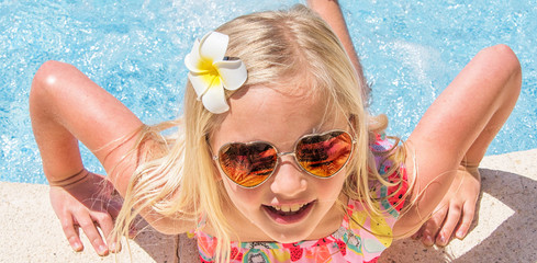Pretty little girl in swimming pool, summer vacations.