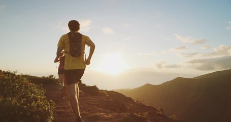 Two adventurous friends running in the mountains with a golden sunset, athletic couple exploring the outdoors together, fitness goals outdoors training for an ultra marathon