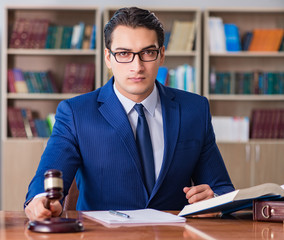 Handsome judge with gavel sitting in courtroom