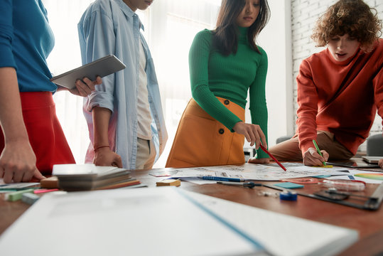 Morning meeting. Group of young and professional designers discussing ideas while working on a new project together in the modern and bright office. Creative agency - Powered by Adobe