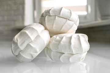 three marshmallows lie on a bright table