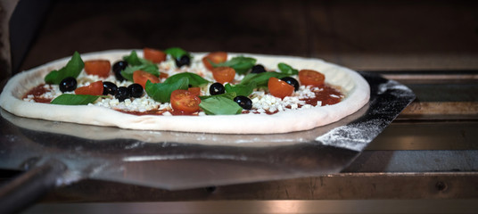 Homemade pizza with tomatoes, mozzarella and basil.