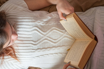 Young girl on bed with a book.