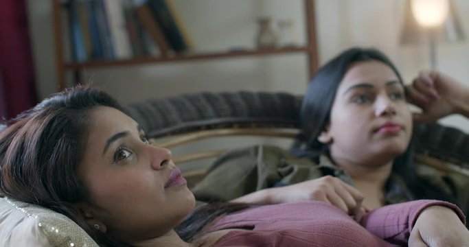 Two females pretending to be annoyed and pissed with each other try to fool around and the chemistry between them makes them laugh off reluctantly as they enjoy each other's come with fun, joy, smile 