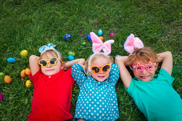 happy kids on easter eggs hunt in spring - 322502088