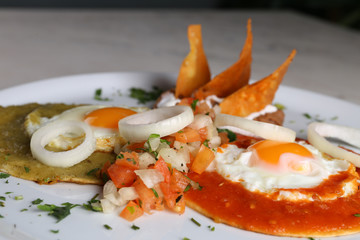 Huevos divorciados, fried eggs on corn tortillas with salsa verde and roja, mexican breakfast 