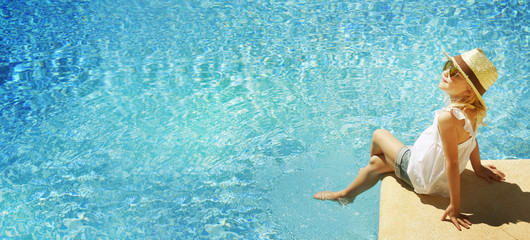 Children blond girl in swimming pool. Summer vacations.