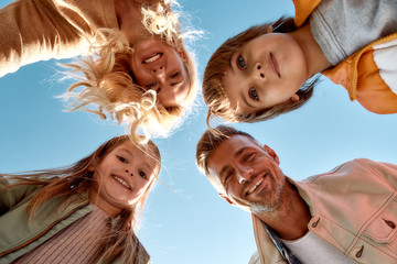 Our family is the best. Bottom view of happy and positive family smiling at camera while standing...