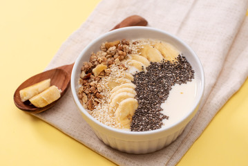 Healthy pineapple, mango smoothie bowl with coconut, bananas, blueberries and granola. Top view scene on a bright background.