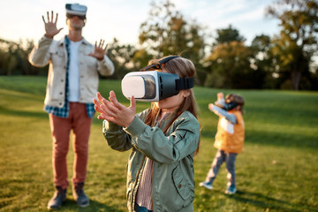 Something new. Family playing in virtual reality glasses outdoors