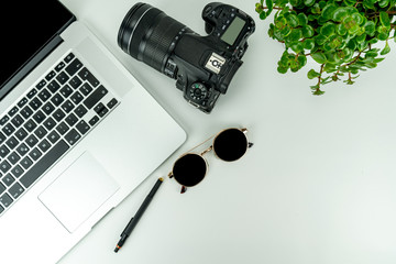 Naklejka premium Flat Lay with notebook, Sunglasses, Plants, pencil and camera