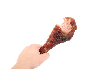 hand holding roasted turkey leg with bite taken , isolated on white background.