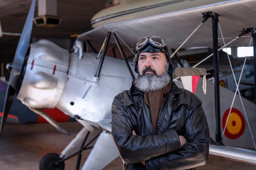 Middle-aged pilot, posing in front of a classic plane