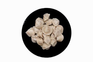 Hot tasty dumplings made of dough and meat on a black plate on a white isolated background. National Russian food.