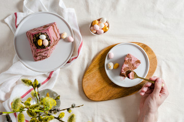 Easter cherry chocolate curd cake with nest and eggs on festive table. Easter card, recipe. Copy space