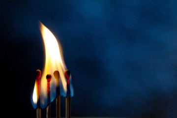 Four burning matches, fire, burnt matches, blurred background