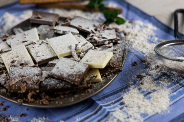 Still life of chocolate seen from above with sugar, cinnamon and mint
