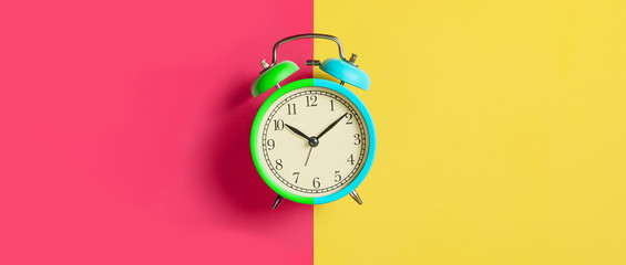 Trendy Multicolored alarm clock on bright colorful background. Top view. Flat lay