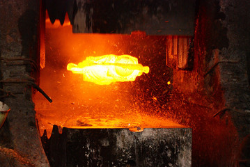 metal forging. hydraulic hammer shapes the red hot billet. the production of high tech parts