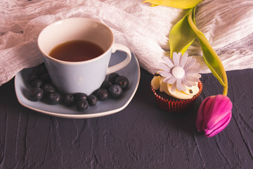 cup of coffee, berries and tulip on the table