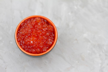 red caviar in a dish on a light table. the concept of a delicious Breakfast, buffet and snack. seafood dish. the view from the top. space for text.