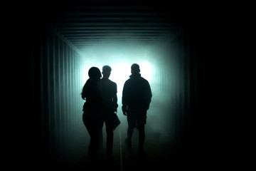 Silhouette of people in a misty tunnel