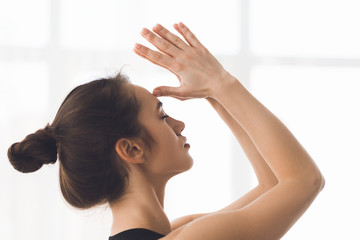 Yogi woman doing namaste gesture touching face with fingers