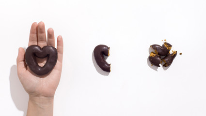 Female hand holding whole cookie heart on white background