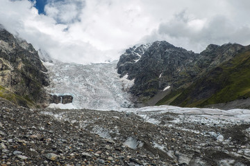 Amazing view to full Adishi glacier icefall and its small waterfall in mountains of Svaneti Georgia