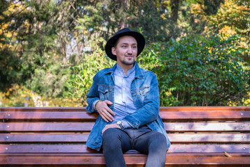 Portrait of a confident and successful young man with a denim jacket and blue shirt outside. Handsome young man outside. Happy guy smiling