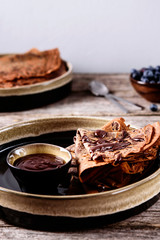 Chocolate Crepes with chocolate sauce and blueberry on vintage wooden table. Selective focus