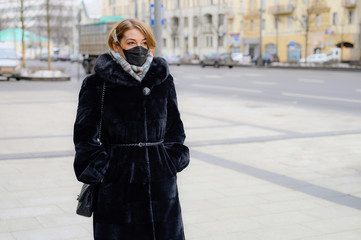 Obraz premium young european woman in protective disposable medical black mask in city outdoor. concept protection of dangerous 2019-nCoV influenza coronavirus, mutated and spreading in China