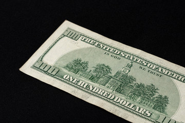 Rear side of old one hundred dollar american currency on black background.