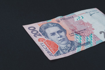 Ukrainian banknote in the face value of two hundred hryvnia is on a black background.