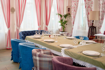 Table set with white plates, napkins , cutlery and wineglasses on table, copy space. Place setting at wedding reception. Table served for banquet in restaurant