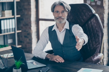 Portrait of his he nice attractive handsome professional gray-haired director shaking hand inviting to startup at industrial loft style workplace workstation indoors