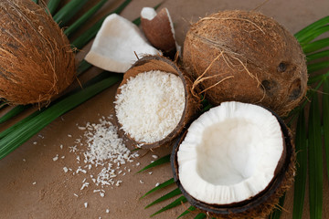 fresh half cut and whole coconuts with coconut flakes on background