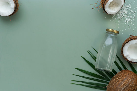 image of bottle full of coconut water and coconuts on green background