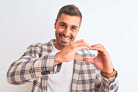 Young handsome business man wearing elegant jacket over isolated background smiling in love showing heart symbol and shape with hands. Romantic concept.