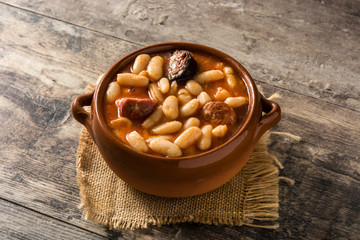 Typical Spanish fabada asturiana in crockpot on wooden table