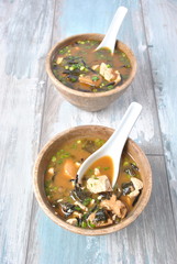 Japanese miso soup with fresh tuna, dried seaweed, tofu, shiitake dried mushrooms in a wooden bowl...