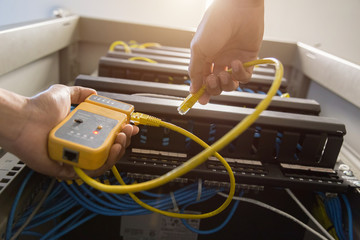 hand with network cables connected to servers in a datacenter,equipment. Tester cable lan in the...